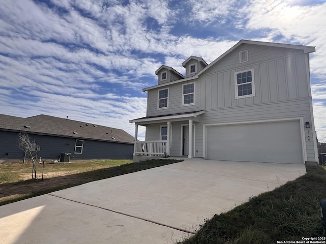 view of front of property with a garage, cooling unit, and a porch