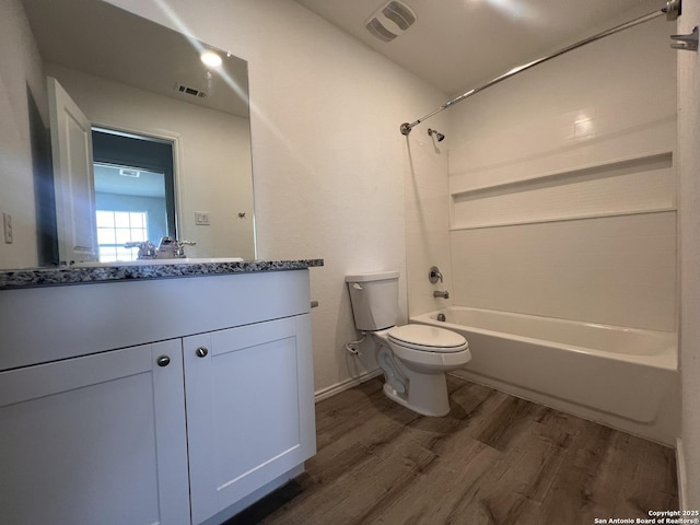 full bathroom featuring wood-type flooring, toilet, shower / bathing tub combination, and vanity