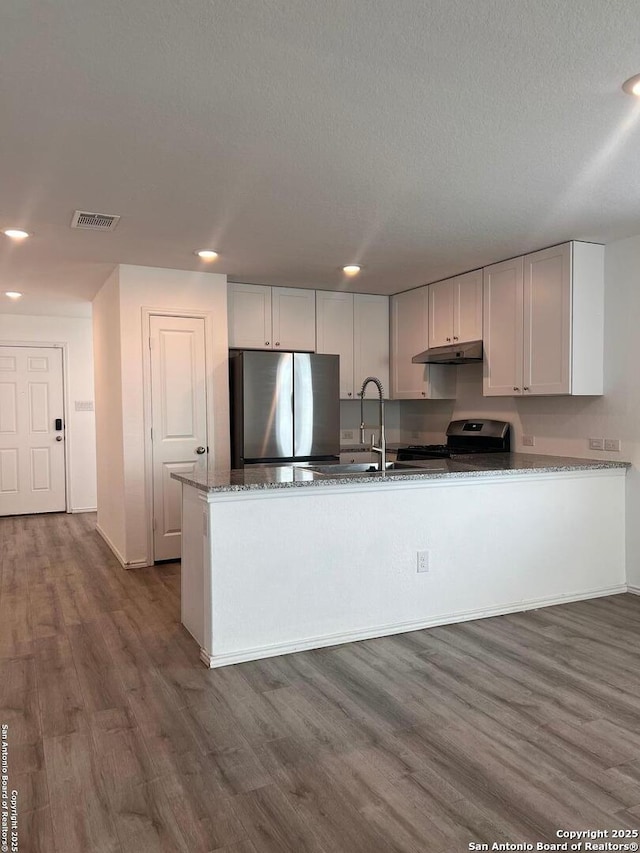 kitchen with white cabinets, dark wood-type flooring, stone countertops, and appliances with stainless steel finishes