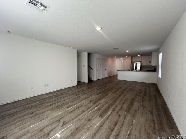 unfurnished living room with hardwood / wood-style flooring and a textured ceiling