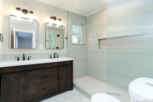 bathroom with a tile shower, backsplash, toilet, and vanity