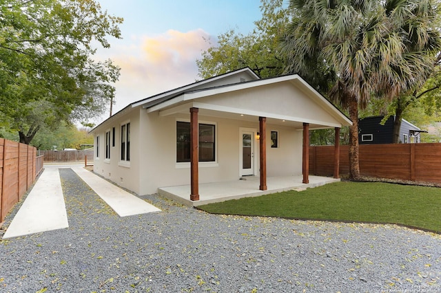 view of front of property with a patio area and a yard