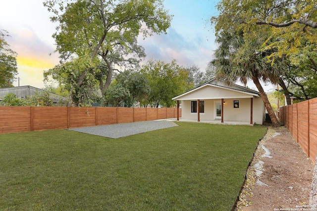 yard at dusk featuring a patio