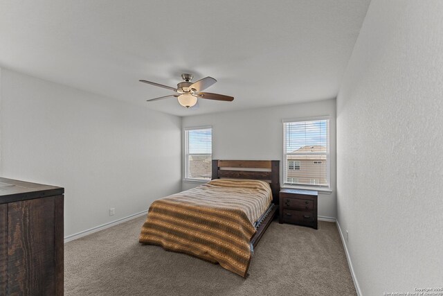 bedroom featuring light carpet, multiple windows, and ceiling fan