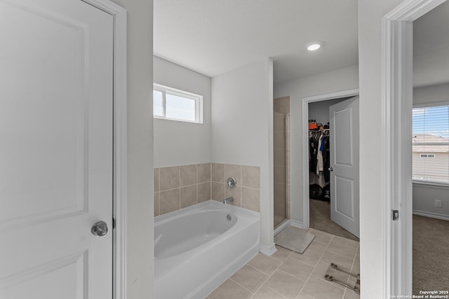 bathroom with separate shower and tub and tile patterned flooring