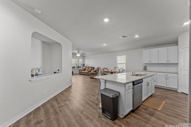 kitchen with white cabinets, tasteful backsplash, an island with sink, sink, and stainless steel dishwasher