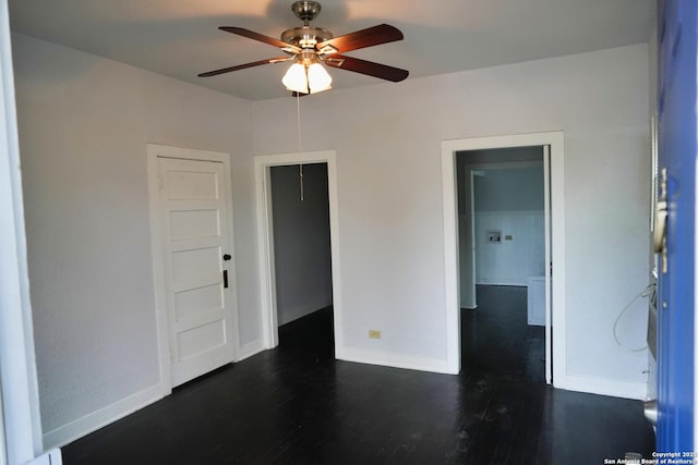 spare room with dark wood-type flooring and ceiling fan