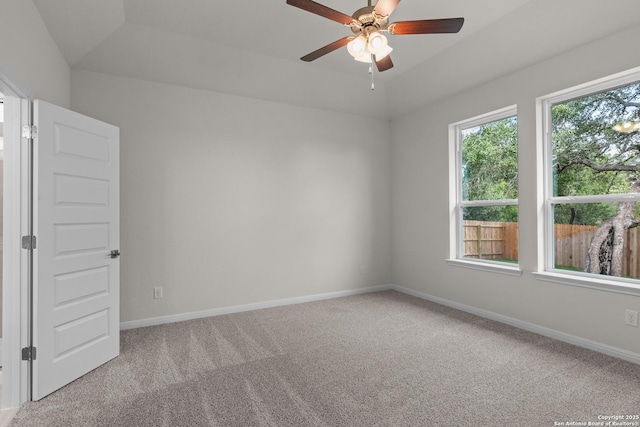 carpeted empty room featuring ceiling fan and a wealth of natural light