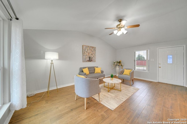 living area featuring hardwood / wood-style flooring, ceiling fan, and vaulted ceiling