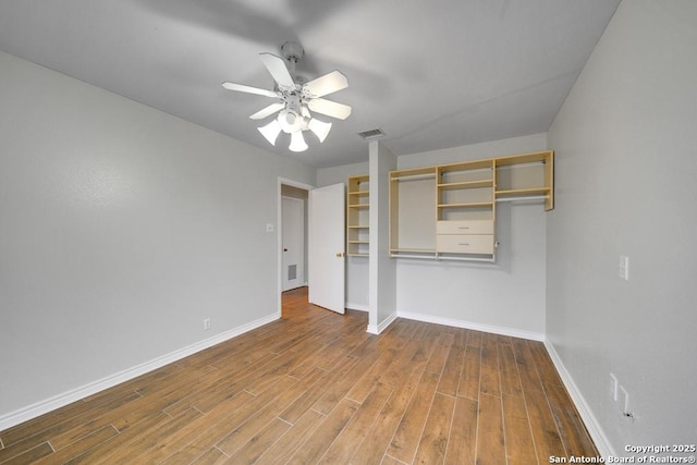 unfurnished bedroom with ceiling fan and a closet