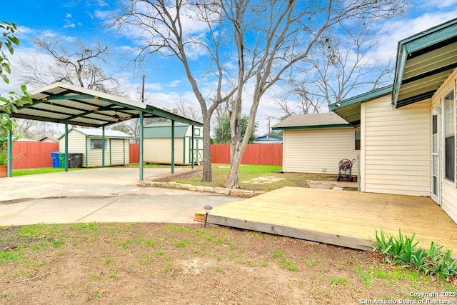 view of yard featuring a patio area, a deck, and a storage unit