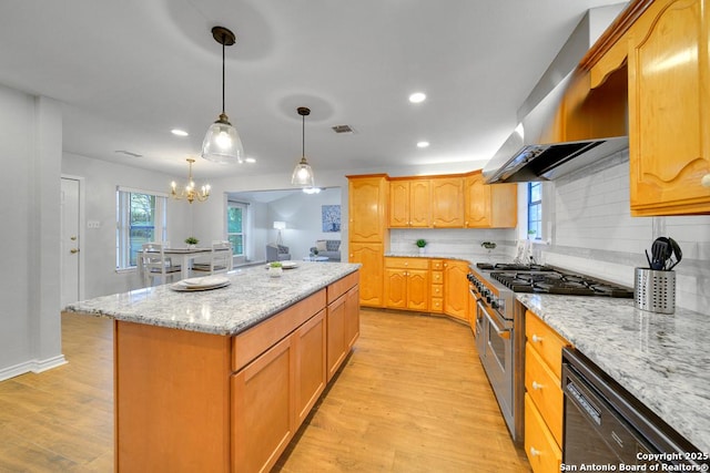 kitchen featuring light stone countertops, a center island, wall chimney exhaust hood, range with two ovens, and black dishwasher