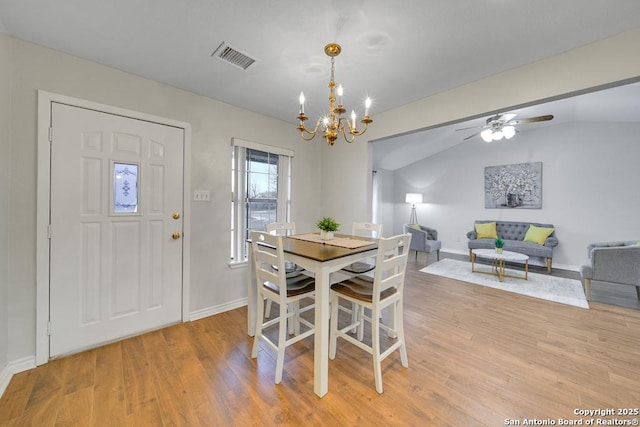 dining area featuring light hardwood / wood-style floors and ceiling fan with notable chandelier