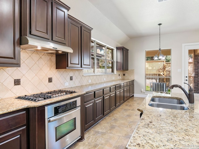 kitchen featuring pendant lighting, appliances with stainless steel finishes, sink, and dark brown cabinets