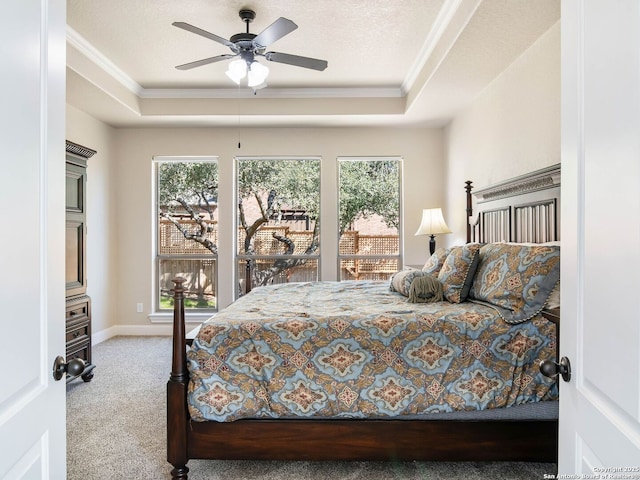 bedroom featuring crown molding, carpet flooring, a tray ceiling, and a textured ceiling