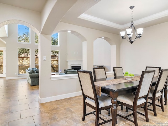 dining space with crown molding, a notable chandelier, and a tray ceiling