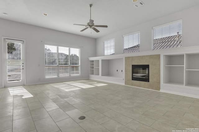 unfurnished living room featuring a fireplace, built in features, light tile patterned floors, and ceiling fan