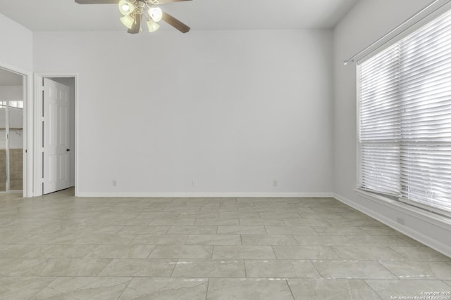 spare room with ceiling fan and light tile patterned floors