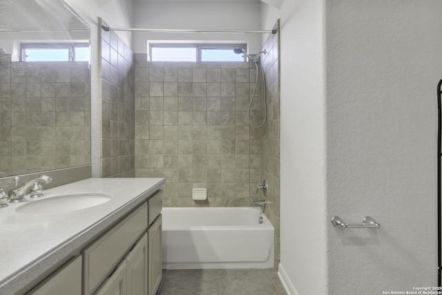 bathroom featuring tiled shower / bath, tile patterned floors, and vanity