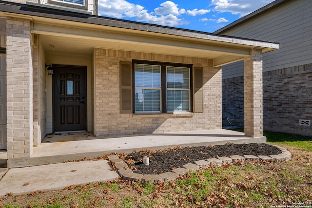 view of exterior entry featuring covered porch