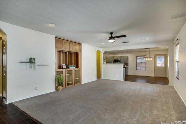 unfurnished living room featuring dark hardwood / wood-style floors and ceiling fan