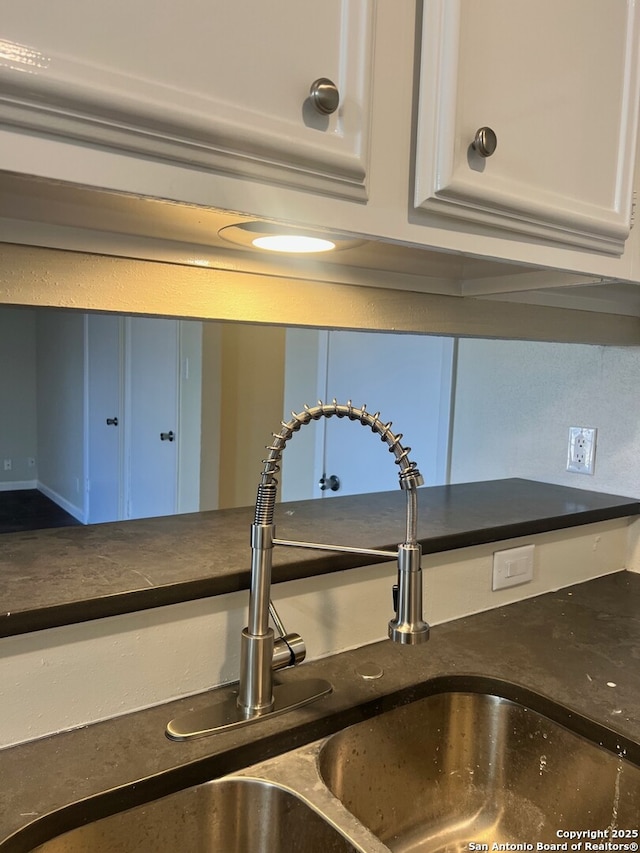 interior details featuring sink and white cabinets