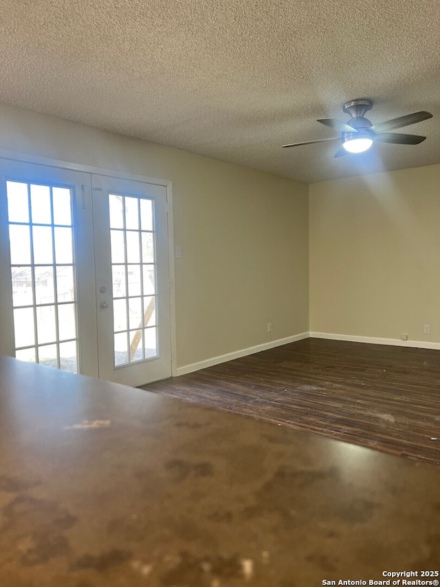 unfurnished room featuring wood-type flooring, a textured ceiling, ceiling fan, and french doors