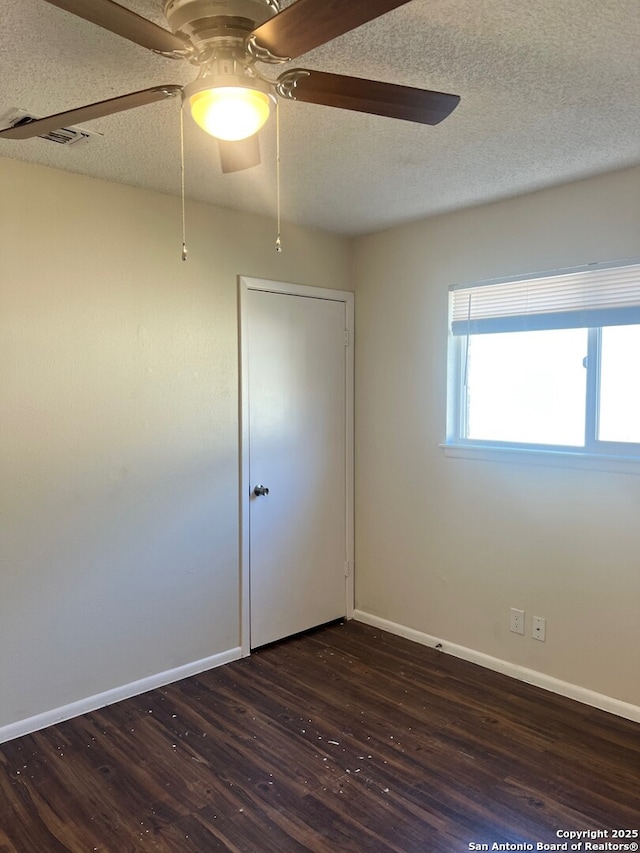 spare room featuring ceiling fan, a textured ceiling, and dark hardwood / wood-style flooring