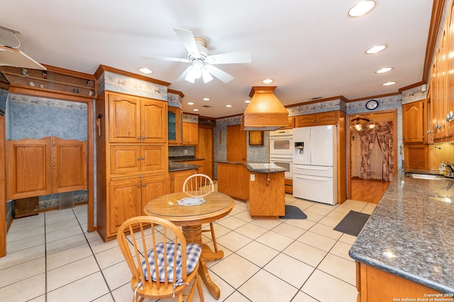 kitchen with a kitchen island, white appliances, ornamental molding, and light tile patterned flooring