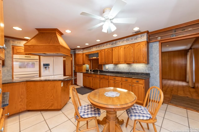 kitchen featuring white appliances, light tile patterned floors, crown molding, and custom exhaust hood