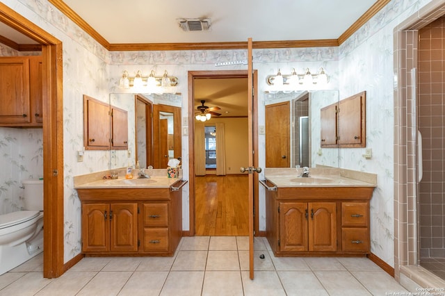 bathroom with tile patterned floors, toilet, ornamental molding, and vanity