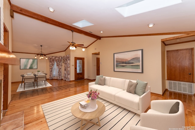 living room featuring light wood-type flooring, lofted ceiling with skylight, and a chandelier