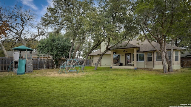 view of yard featuring a playground and a patio