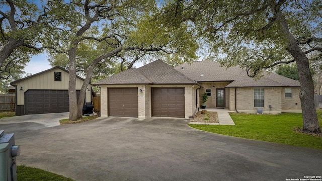 single story home with a garage and a front lawn