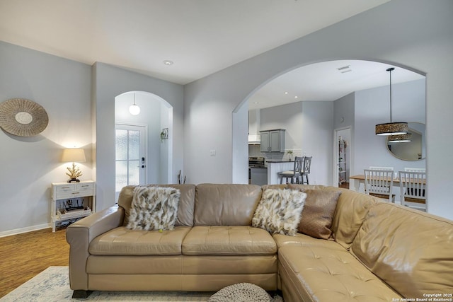 living room featuring lofted ceiling and light wood-type flooring