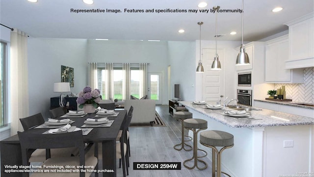 kitchen with oven, built in microwave, decorative backsplash, white cabinets, and decorative light fixtures