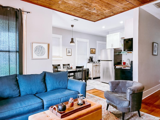 living room with sink, light wood-type flooring, and wood ceiling