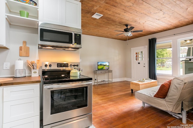 kitchen with butcher block counters, appliances with stainless steel finishes, wooden ceiling, wood-type flooring, and white cabinetry