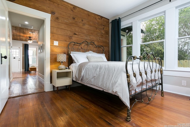 bedroom featuring wood-type flooring and wooden walls