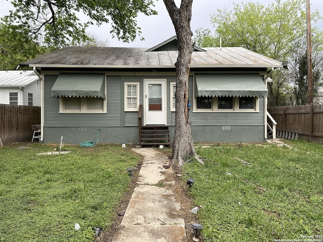 bungalow-style home with a front yard