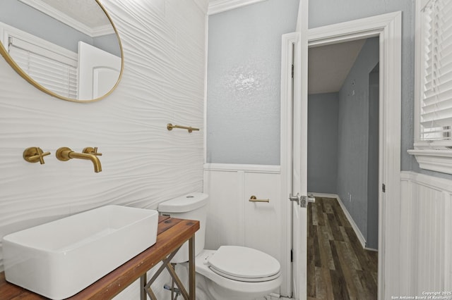 bathroom featuring sink, hardwood / wood-style floors, toilet, and ornamental molding