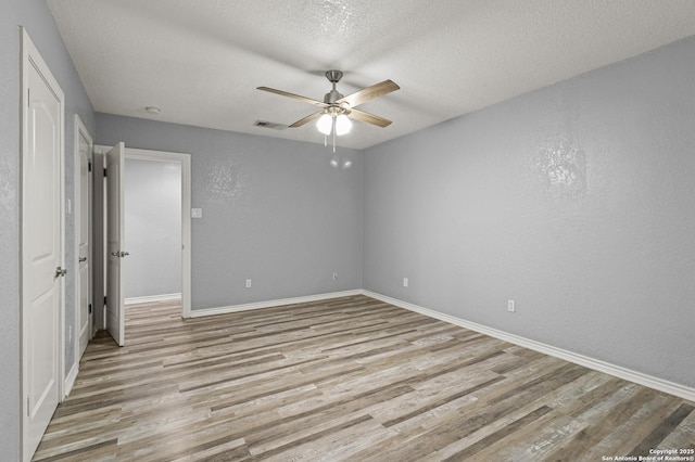 spare room featuring ceiling fan, a textured ceiling, and light hardwood / wood-style flooring