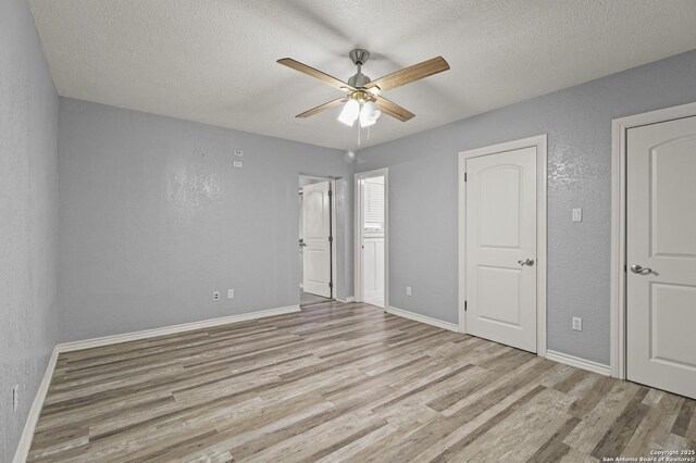 unfurnished bedroom featuring light wood-type flooring, ceiling fan, and a textured ceiling