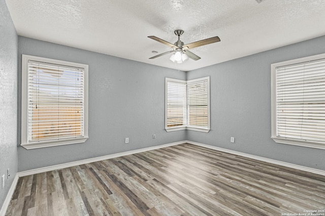 empty room with hardwood / wood-style flooring, a textured ceiling, and ceiling fan