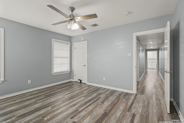 spare room featuring hardwood / wood-style floors, a textured ceiling, and ceiling fan