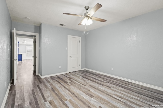 unfurnished bedroom with ceiling fan, a textured ceiling, and light hardwood / wood-style flooring