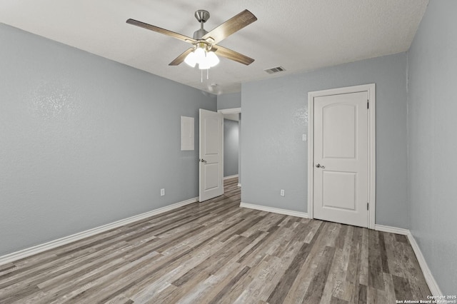 unfurnished bedroom featuring light hardwood / wood-style floors, a textured ceiling, and ceiling fan