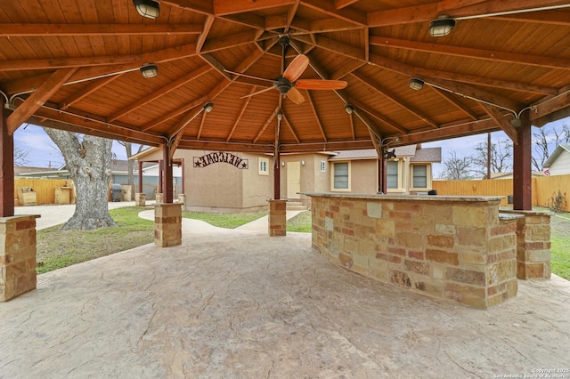 view of patio / terrace featuring ceiling fan, an outdoor bar, and a gazebo