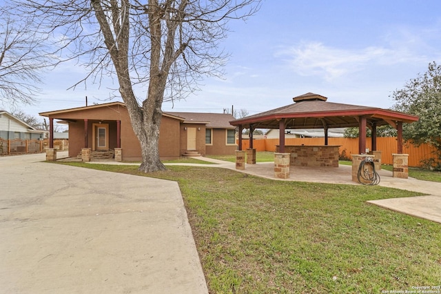 view of property's community with a lawn, a gazebo, and a patio