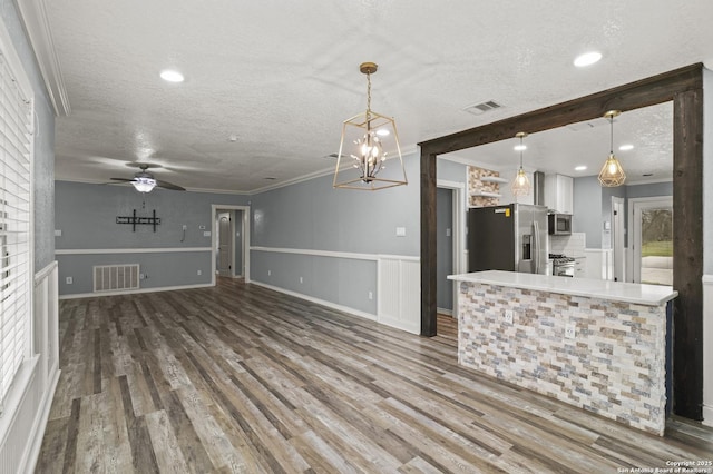 kitchen with stainless steel appliances, hanging light fixtures, and a textured ceiling